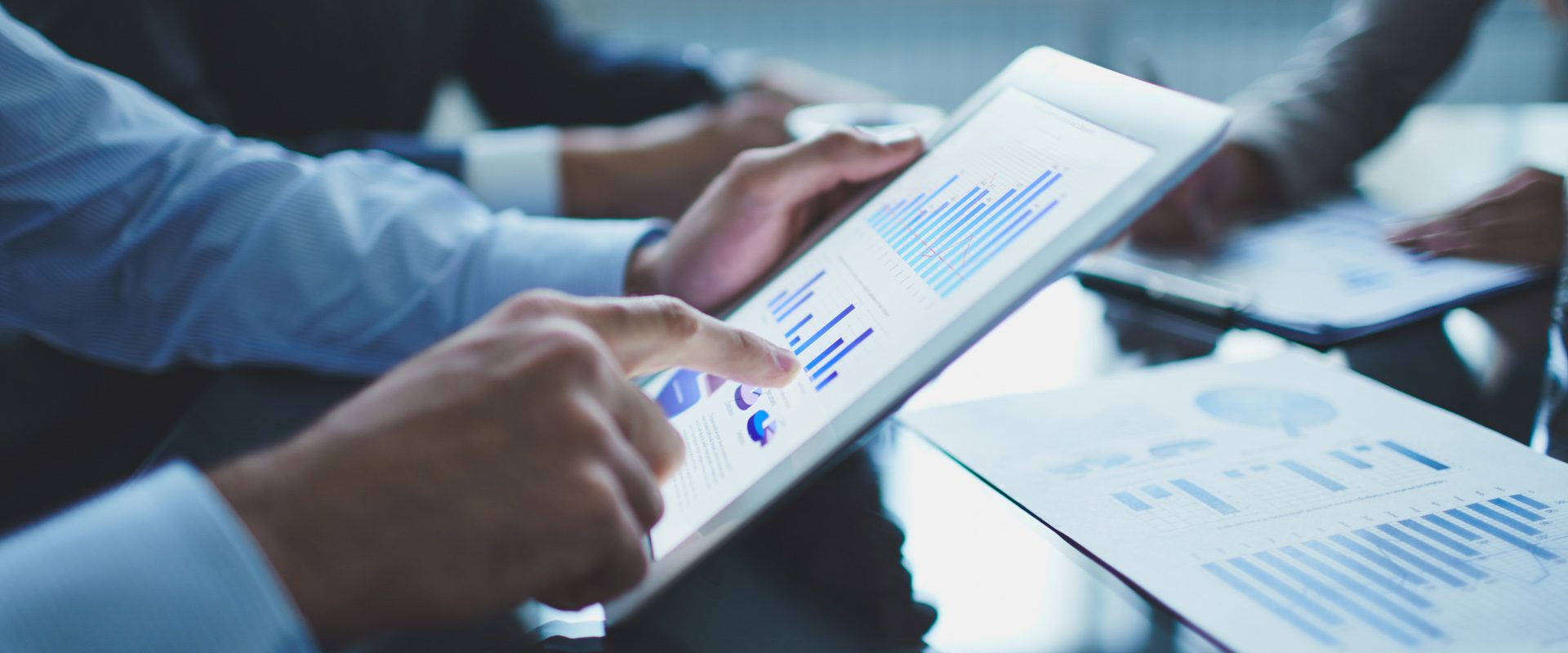 Analyzing electronic document Image of businessperson pointing at document in touchpad at meeting